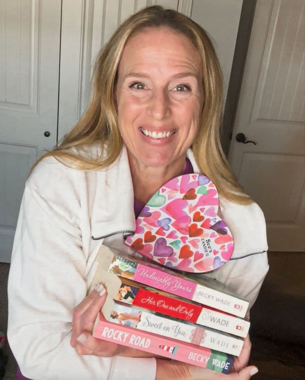 Reader holding a stack of Becky Wade novels