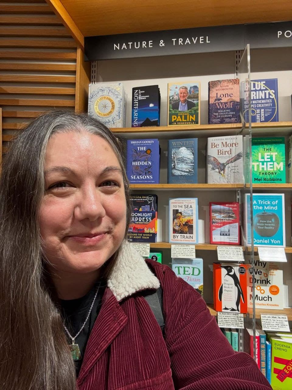 Member browsing books in a Nature & Travel section